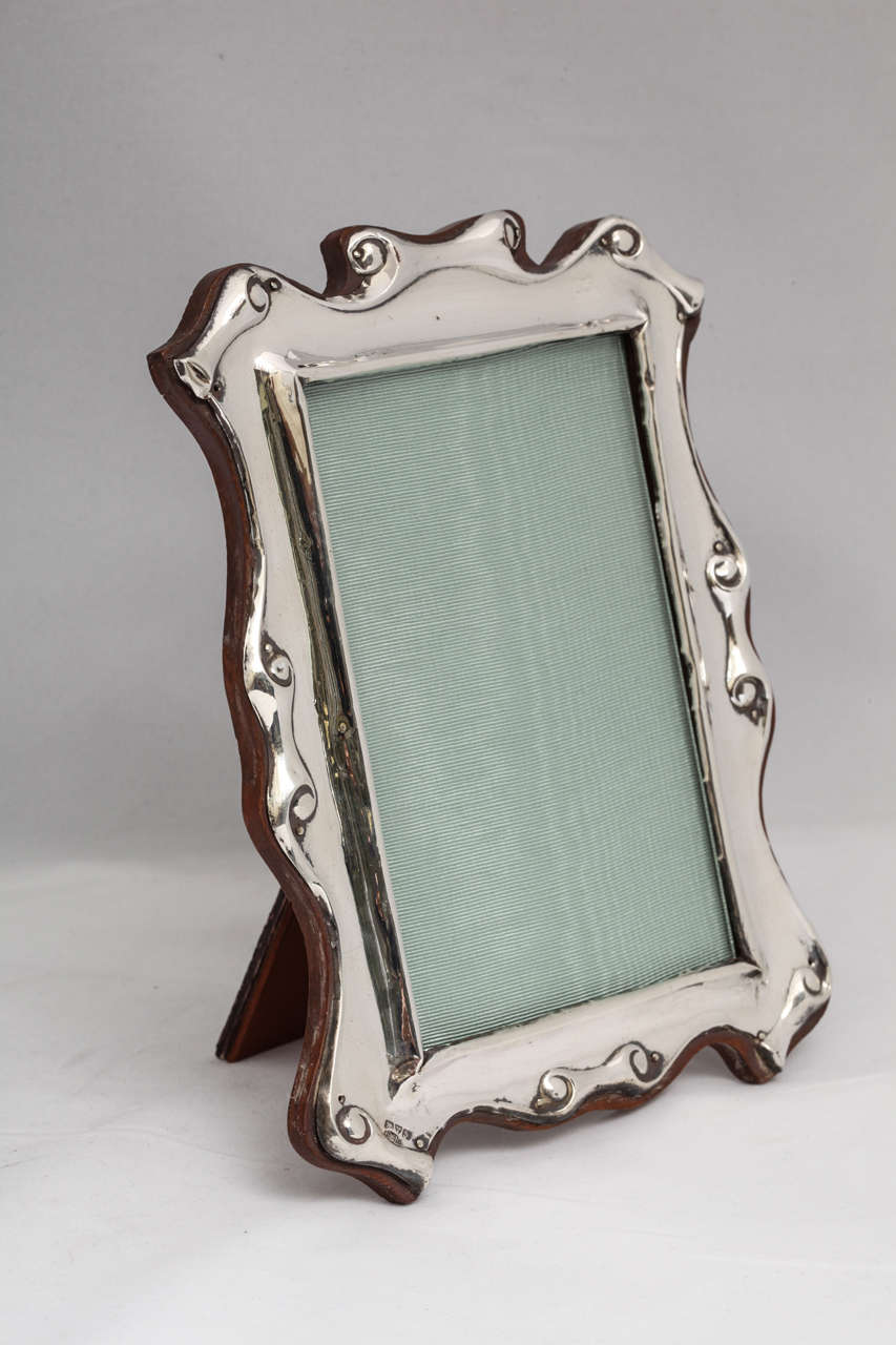Edwardian, sterling silver, scroll design picture frame, Chester, England, H. Williamson Ltd. - Maker. Mounted on wood back. Measures: 8 3/4