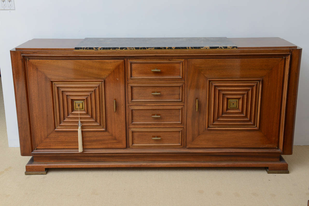 The top with inset marble above four central drawers flanked by cabinet doors, the style of Maxime Old.

 