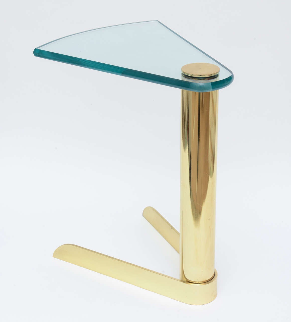 This wonderful and timeless columned and pie shaped base of polished brass and glass make this a sculptural and fun side table. The top unscrews from the base.
It has a great weight to it. The polished glass is 1 inch thick. There is a lacquer
