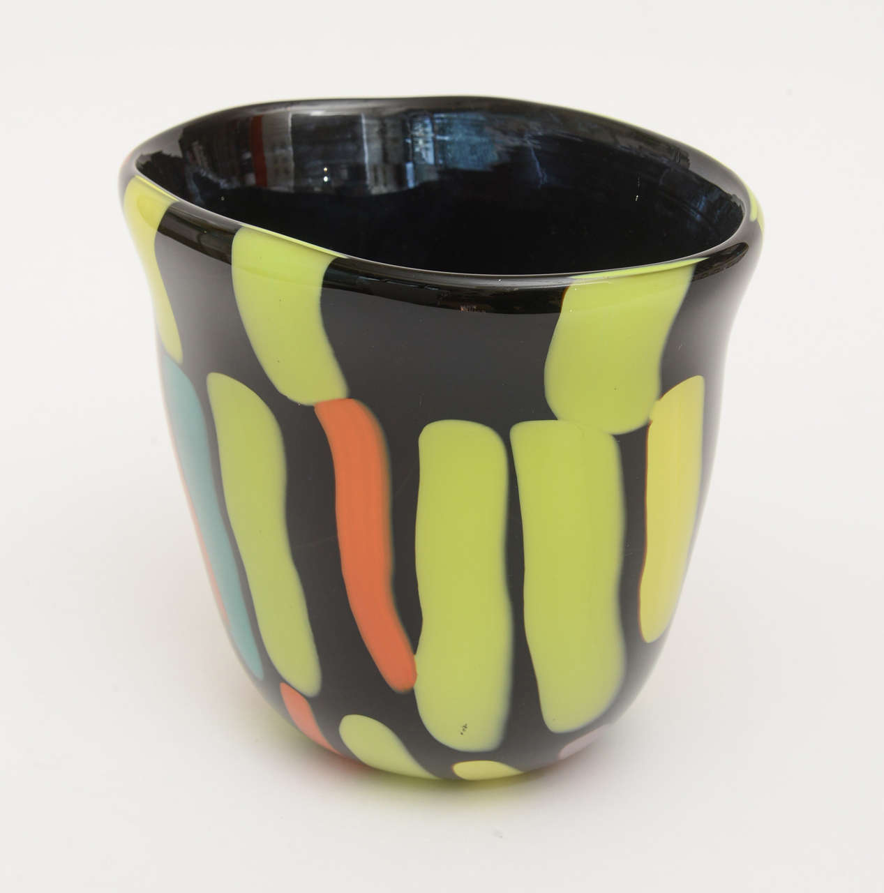 The black glass is the dramatic background for a wonderful painterly palette of arrays of luscious colors in this signed Italian Murano glass vase. It is the signed work of Fratelli Pangnin Murano. It is from the 1980s. It has hues on both sides and