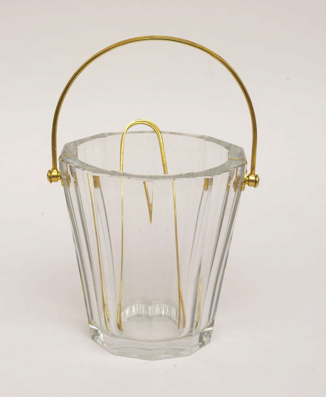 Always Classic, always timeless. This heavy lovely signed Baccarat crystal ice bucket or split champagne bucket has fluted columns.
Has heavy polished brass handle and thongs. They call this the butler ice bucket. It is 12