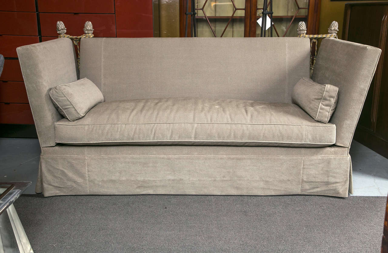 The Canterbury sofa evokes bold style, delivering a sophisticated presence to the modern living room. Edgy lines form the seat's unconventional silhouette, while finial tie backs grace each corner with elegant appeal. Nailhead trim lines the frame