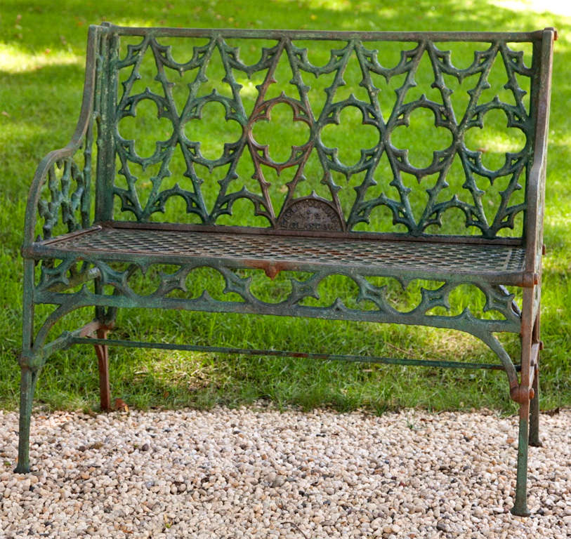 A cast-iron gothic revival seat, the back and arms pierced with tracery and quatrefoils and with hexagon pierced seat, the legs joined by stretchers, marked 