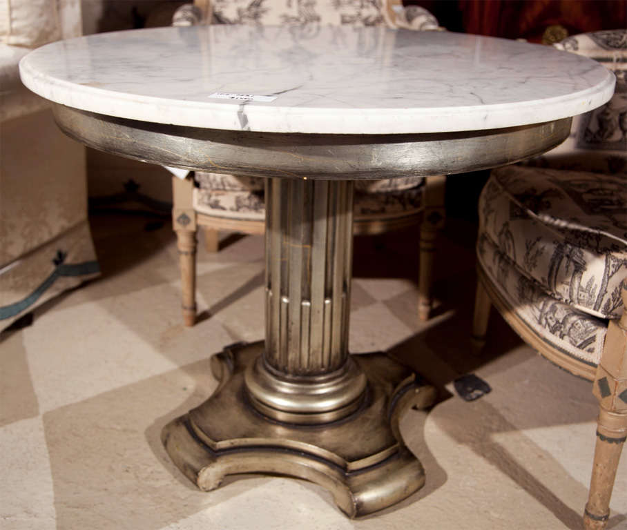 French Empire style center table, circular white marble top a silver gilt base supported by a fluted pedestal, raised on wooden base.