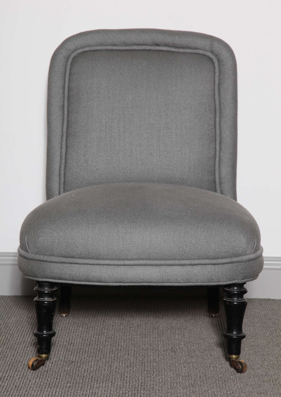 Pair of Napoleon III slipper chairs with ebonized turned legs and original casters. Upholstered in linen.