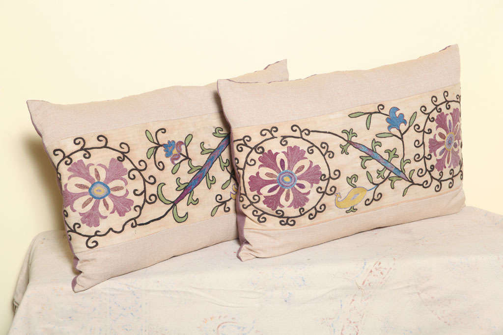 Pair of pillows made of antique suzani textile fragment.<br />
Off white front border linen, with purple back.
