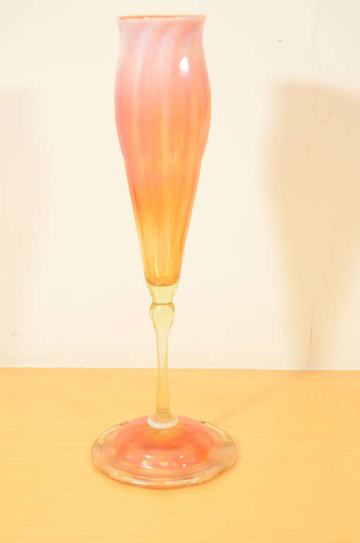 Tiffany Studios, Favrile glass, floriform vase, with unusual coloring. Orange-butterscotch color flows into opalescent glass with pink highlights. It has a clear glass stem. Orange and gold iridescent foot with a circle of blue iridescent