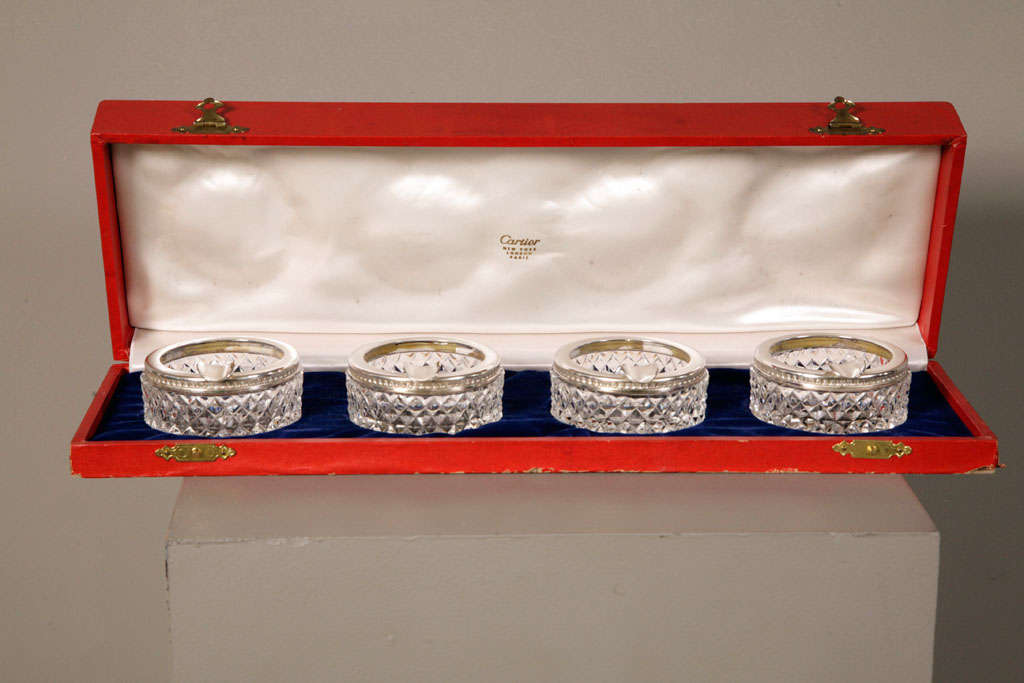 Charming set of four immaculate, cut glass and silver ashtrays by Cartier with its original box. Would make a very elegant addition to a dinner party table.