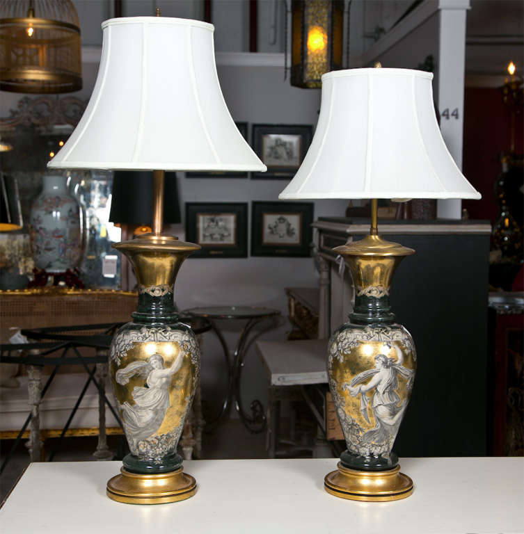 Pair of exceptional Classical style reverse glass table lamps, circa 1940s, urn-shaped form depicting beautiful pattern of goddess on gold-leaf background, supported on circular wooden bases. Shades not included.