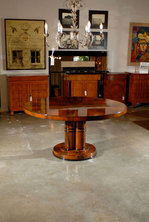 French Art Deco circular dining table raised on a double pedestal base, with starburst grain top.