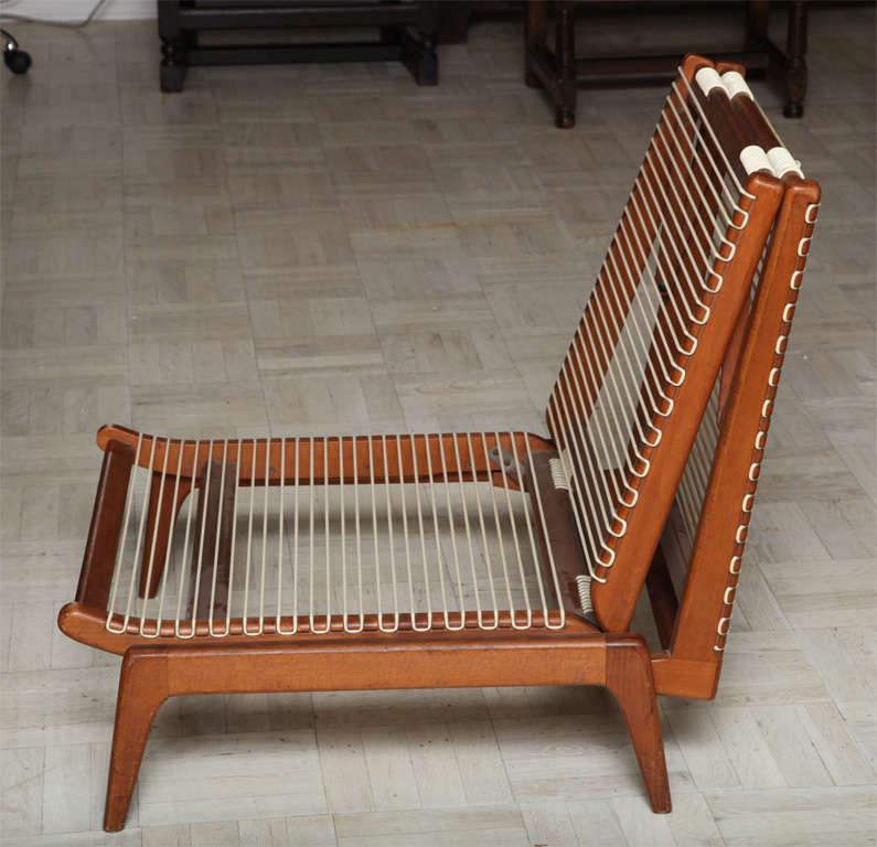 Mid-20th century cherrywood folding chair unfolding to create a chaise, plastic stringing.

Stock no: LS0056.