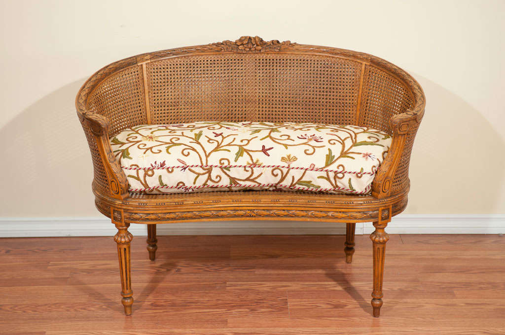 Lovely hand carved details on a caned Louis XVI style canape.
The double caned back and sides is in excellent condition.
The wool embroidery dawn seat cushion has been added.