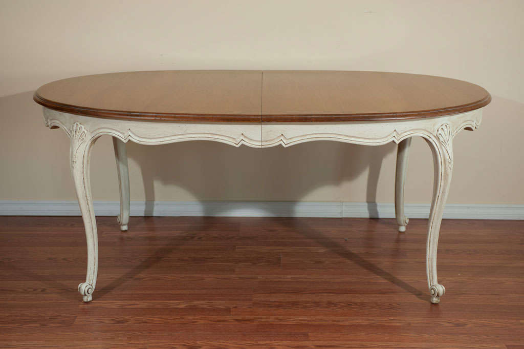 Louis XV style dining table in elm, top has been left natural and lower part painted with an antique finish. The apron has nice curved molding and shell design carving at each leg. The table has 2 leaves of 18