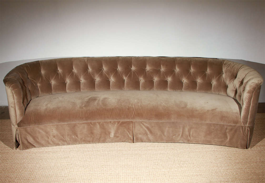 Grand and gorgeous, this exquisite 8-foot-long tufted velvet sofa will have you feeling like a proper Hollywood starlet. Upholstered in a putty-grey velvet, with a single, tight bench seat, a low, tufted back, and a kick-pleat skirt. Truly