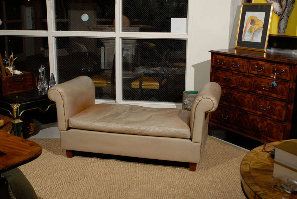 Early 20th Century French Art Deco Period settee that converts into a chaise or daybed. It is covered in a taupe leather and features a separate cushion and pair of bolsters (not pictured). The leather upholstery is original to the piece and shows