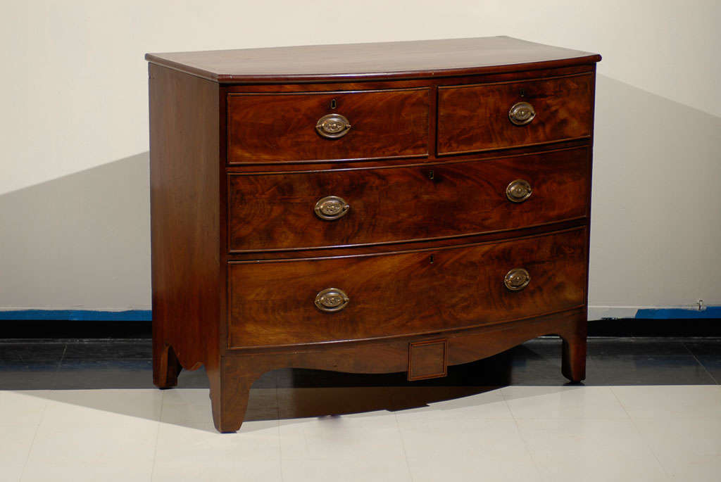 English Regency Bow Front Chest of Mahogany with splay feet.