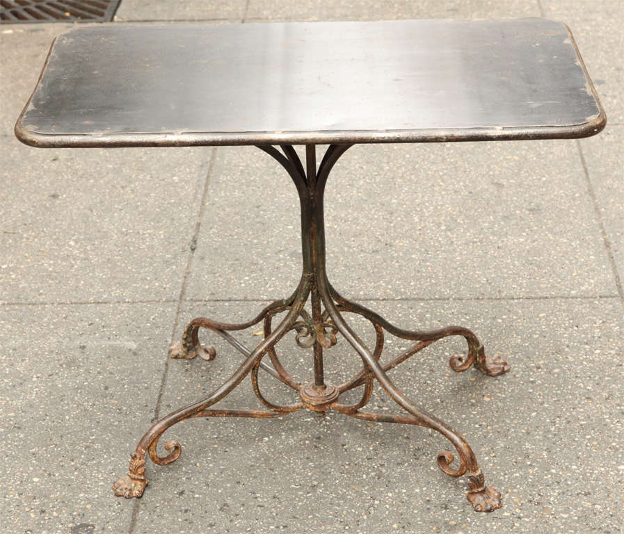Fine late 19th century French wrought iron bistro table signed indistictly on the base having nice surface and of good heavy gauge metal, the recangular top over scrolled base, the feet with cast iron paws.