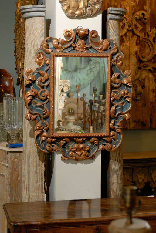 A 19th century Italian Rococo style painted and carved mirror with traces of gilding.