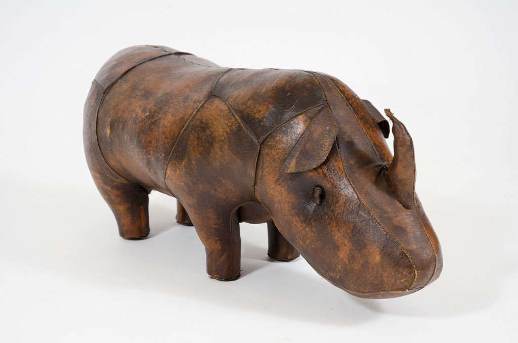 A handmade stuffed rhino footstool with wire and wood frame, wool stuffing and stained leather with a waxed finish. By Omersa. England, circa 1965.