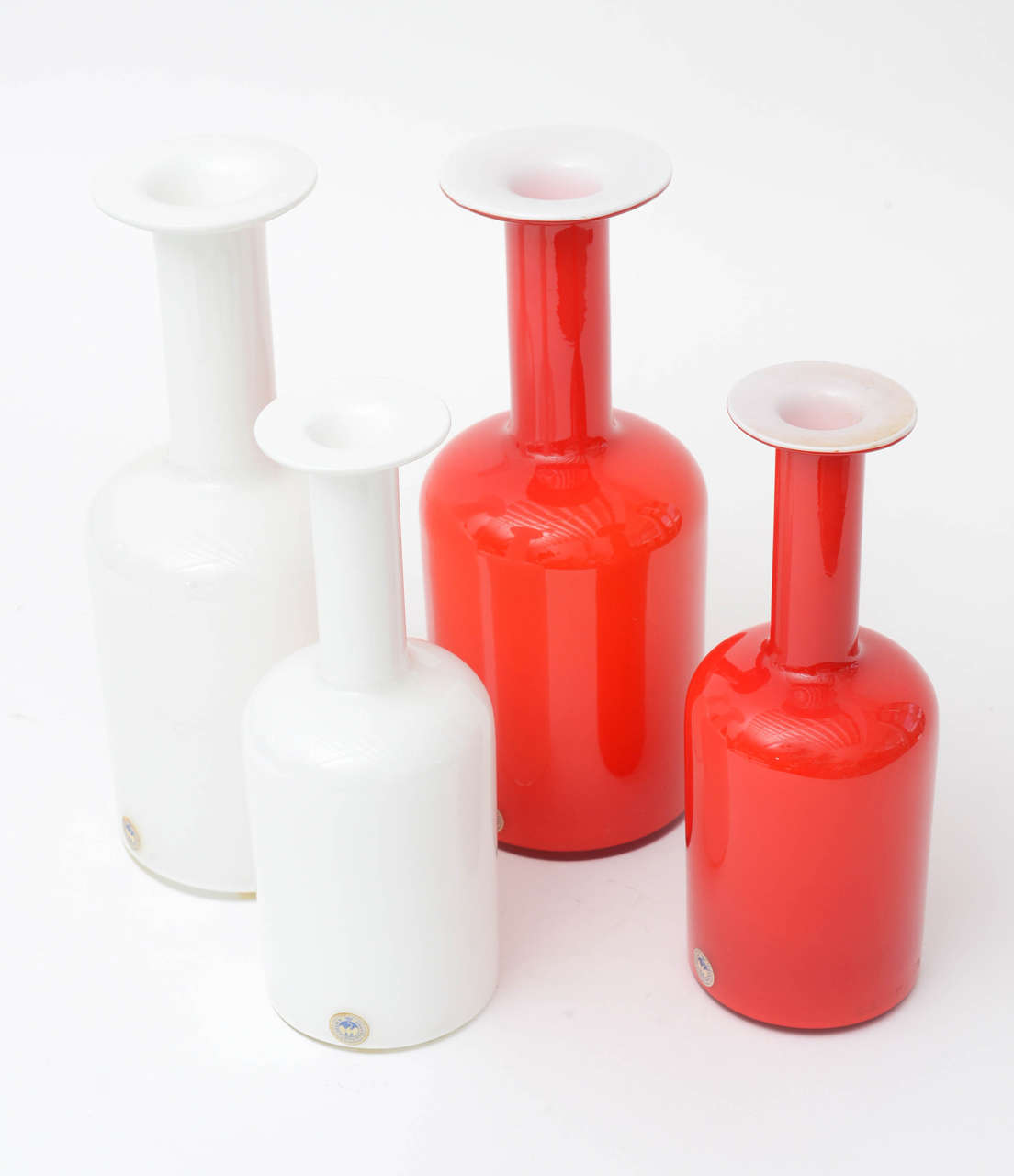 Amazing set of four  Vintage  cased glass Vases By holmegaard . 2 white and 2 red . Lg. Vases measure 12" tall 5" dia.  Smaller 10" tall 3.75 " dia. I will sell the pieces as set of 2 either in white or red . Each set will go for