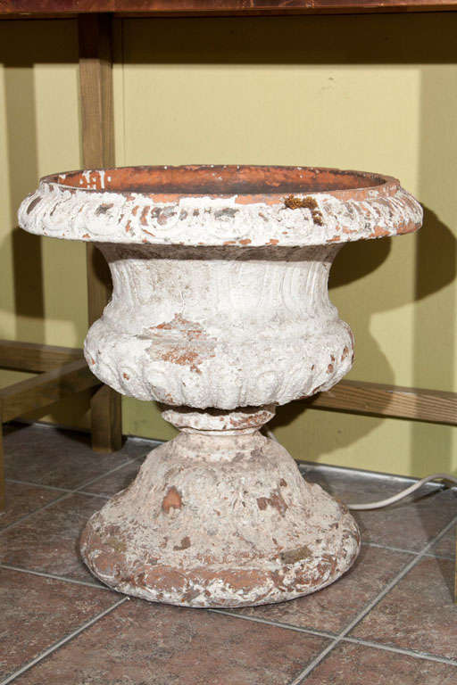 Decorated with an interlacing design, these urns retain their original white & pink-ochre patina