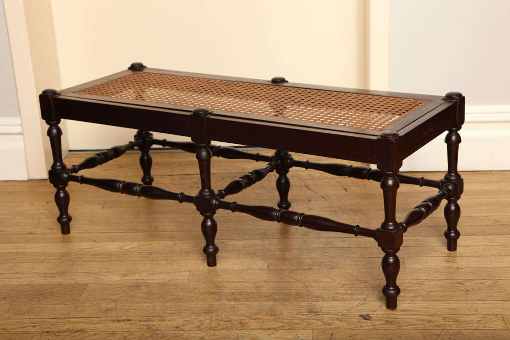 A French mahogany small scale bench, the rectangular inset top with caning, the base in the form of 6 turned legs joined by front and side stretchers.