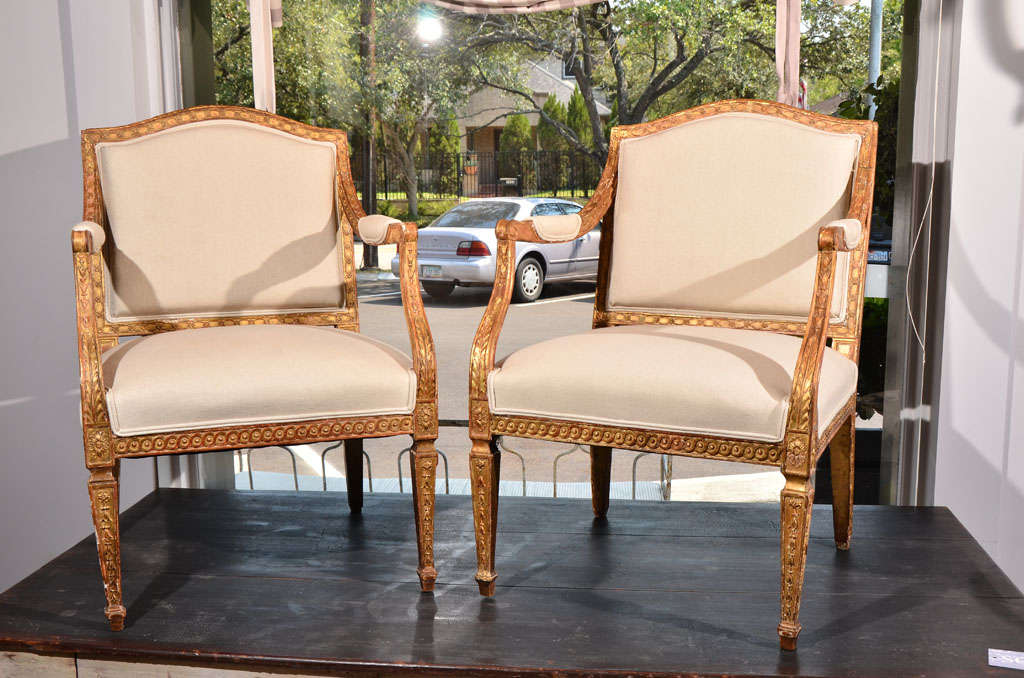 Beautiful pair of Italian chairs, with soft gilding, great condition and carving. Early 19th century.  Upholstered in a neutral de la couna linen. c. 1800
