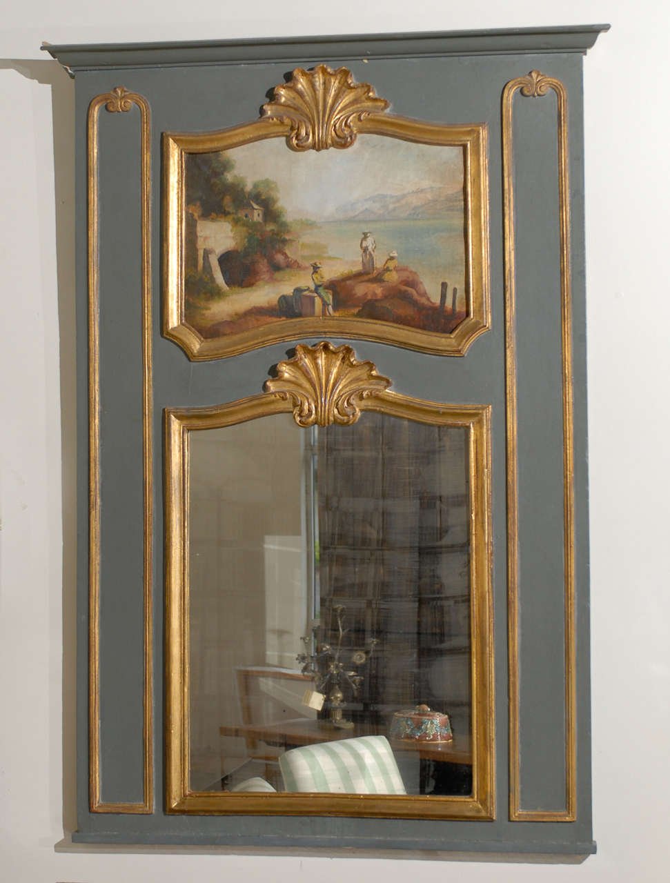 Trumeau Mirror Louis XV-XVI French

Louis XV/XVI traditional Trumeau mirror with a flat  molded cornice; the upper panel with shell crest and shaped raised molding trimmed with gold leaf, enclosing a landscape scene of 3 figures by a lake, a stone