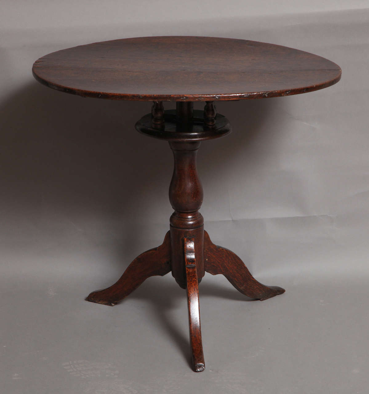 Rare and quirky early 18th Century Welsh oval tilt top table with birdcage mechanism, the richly patinated two plank top over, balustrade turned birdcage and vernacularly fashioned locking system, the shaft turned in the same manner, over shaped and