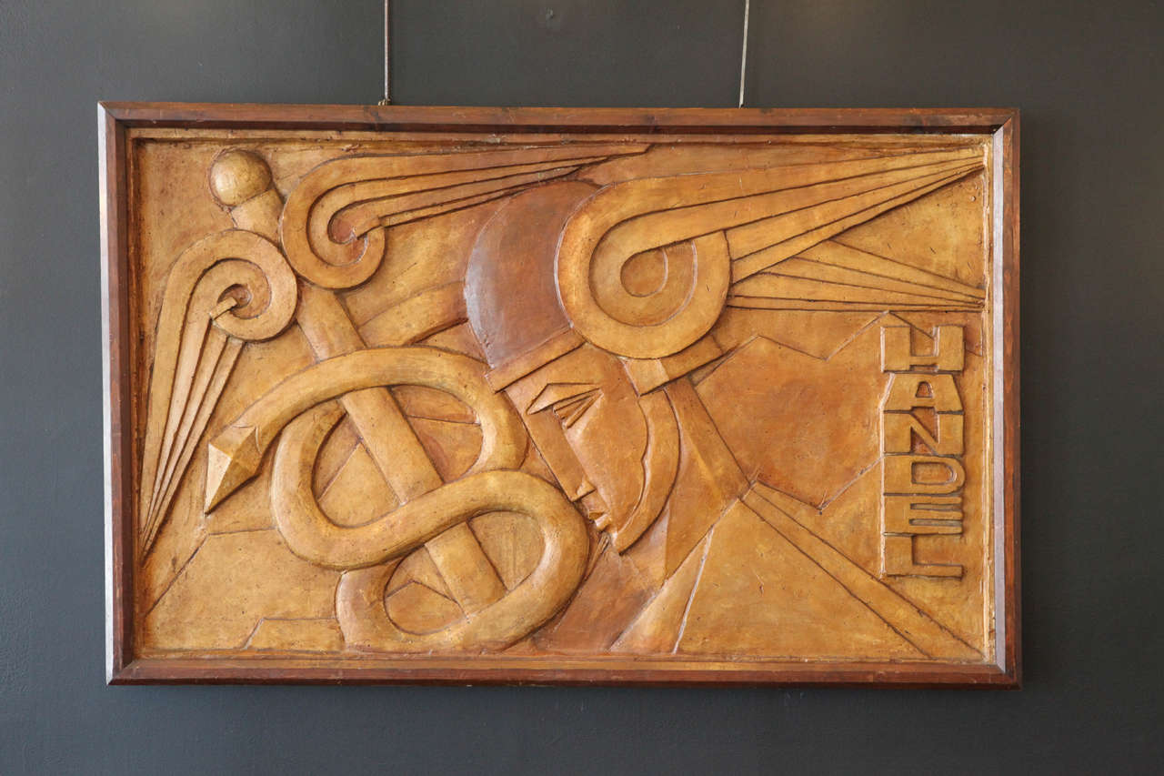 Relief panel of Hermes and his caduceus signed by Handel. Plaster with ochre patina. In original condition.