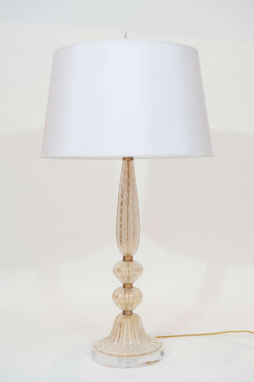 A tall and prominent Murano table lamp with controlled glass bubbles and gold inclusions. New Lucite base contrasts beautifully with the original brass spacers.
Shade optional.