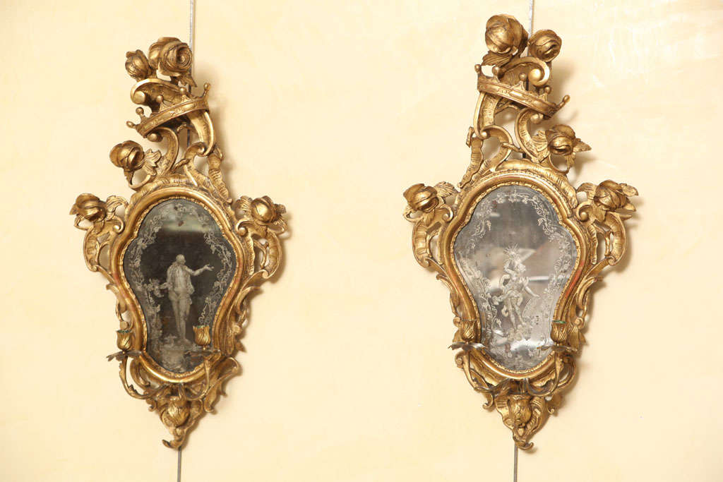 A exquisite pair of Italian 19th century wood and gilt sconces.<br />
Each having juxtaposed etched figures in the center,also each having two candelabra arms