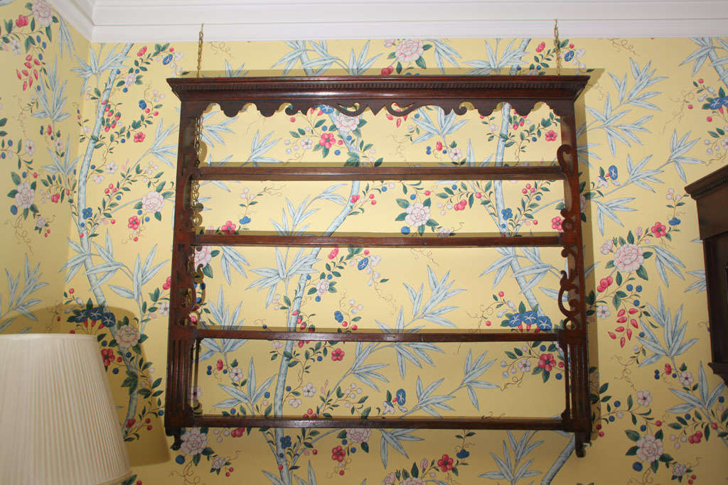 George III mahogany and oak fretwork hanging plate rack, having a dentil moulded and shaped and pierced cornice and applied fret mounding to the front edges, with four shelves. Welsh, circa 1780.
 