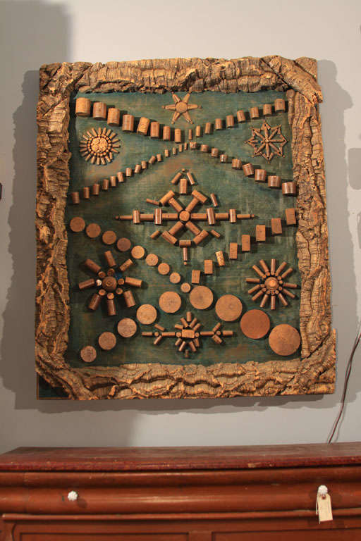 Pieza de exposición del fabricante de corcho Folk Art con muestras de todos los tamaños y formas de corcho disponibles para la venta.  Los corchos están dispuestos en formas geométricas y montados sobre un tablero recubierto de terciopelo,