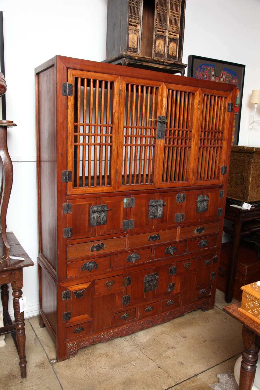 A grain storage cabinet in elm wood with multiple compartments and drawers and heavy brass hardware. From Tianjin, China