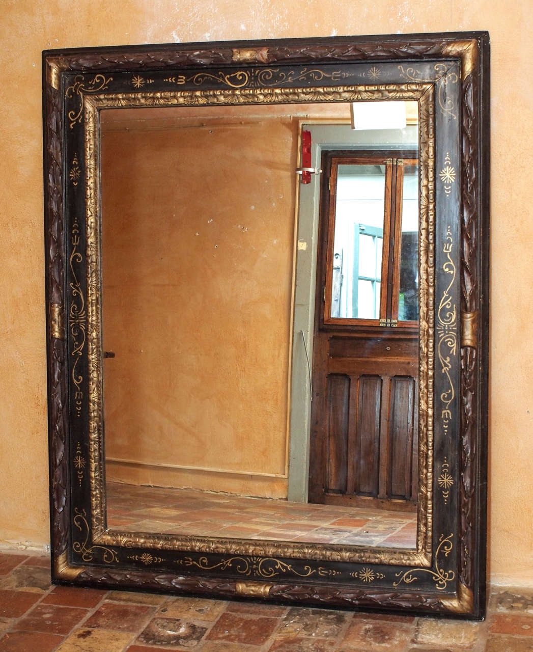 Late 19th Century French Black and Gold Gilded Wooden Mirror with Carved Leaves