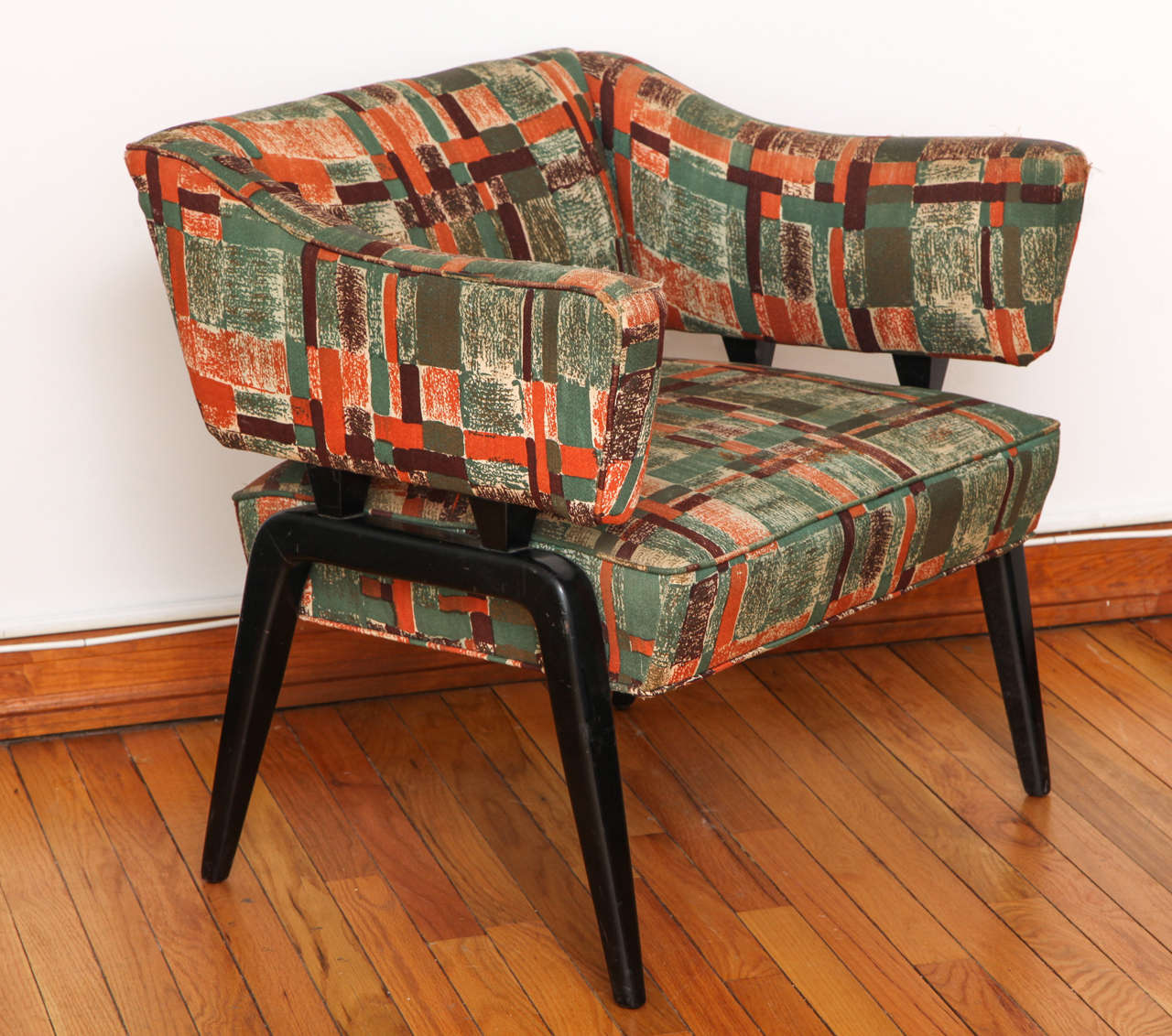 Unique 1950s armchair with a semi-floating backrest and ebonized, tapered legs. Seat height is 15.5
