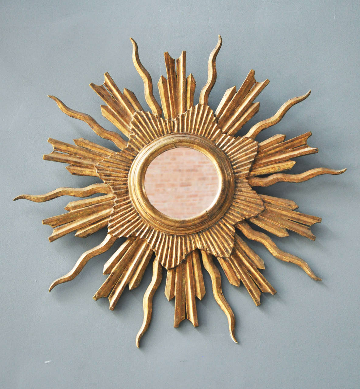 A French sunburst mirror with wonderfully carved and gilt wood rays, circa 1920s.