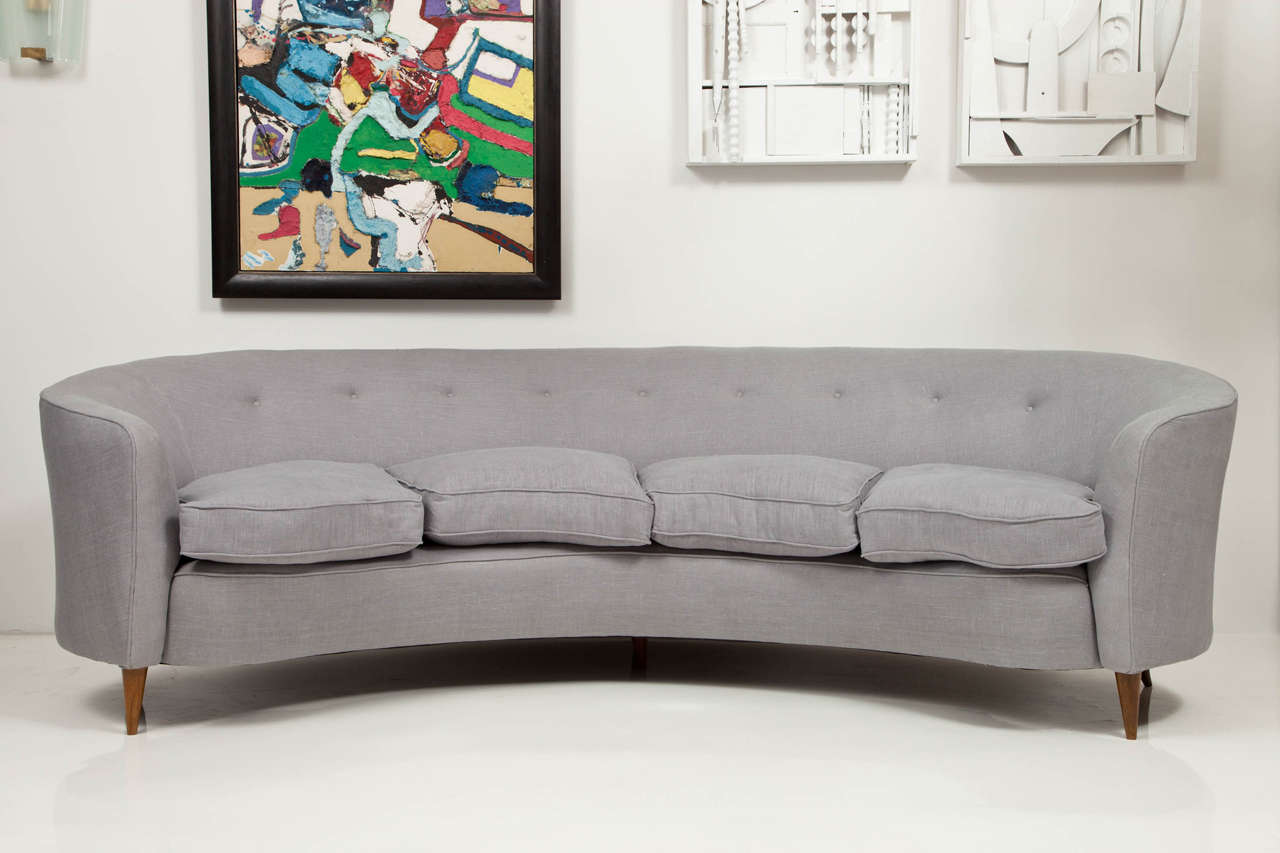 Large curved Italian sofa with polished walnut legs, reupholstered in pale grey linen.