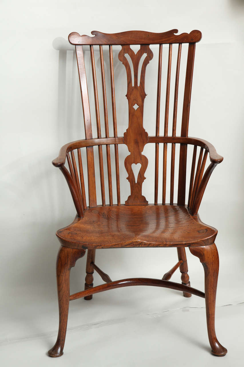 Very fine 18th Century English fruitwood and elm comb back windsor armchair, having shaped cresting over pierced back splat, the deeply saddled seat over cabriole front and turned rear legs joined by crinoline stretcher, the whole witl pleasing