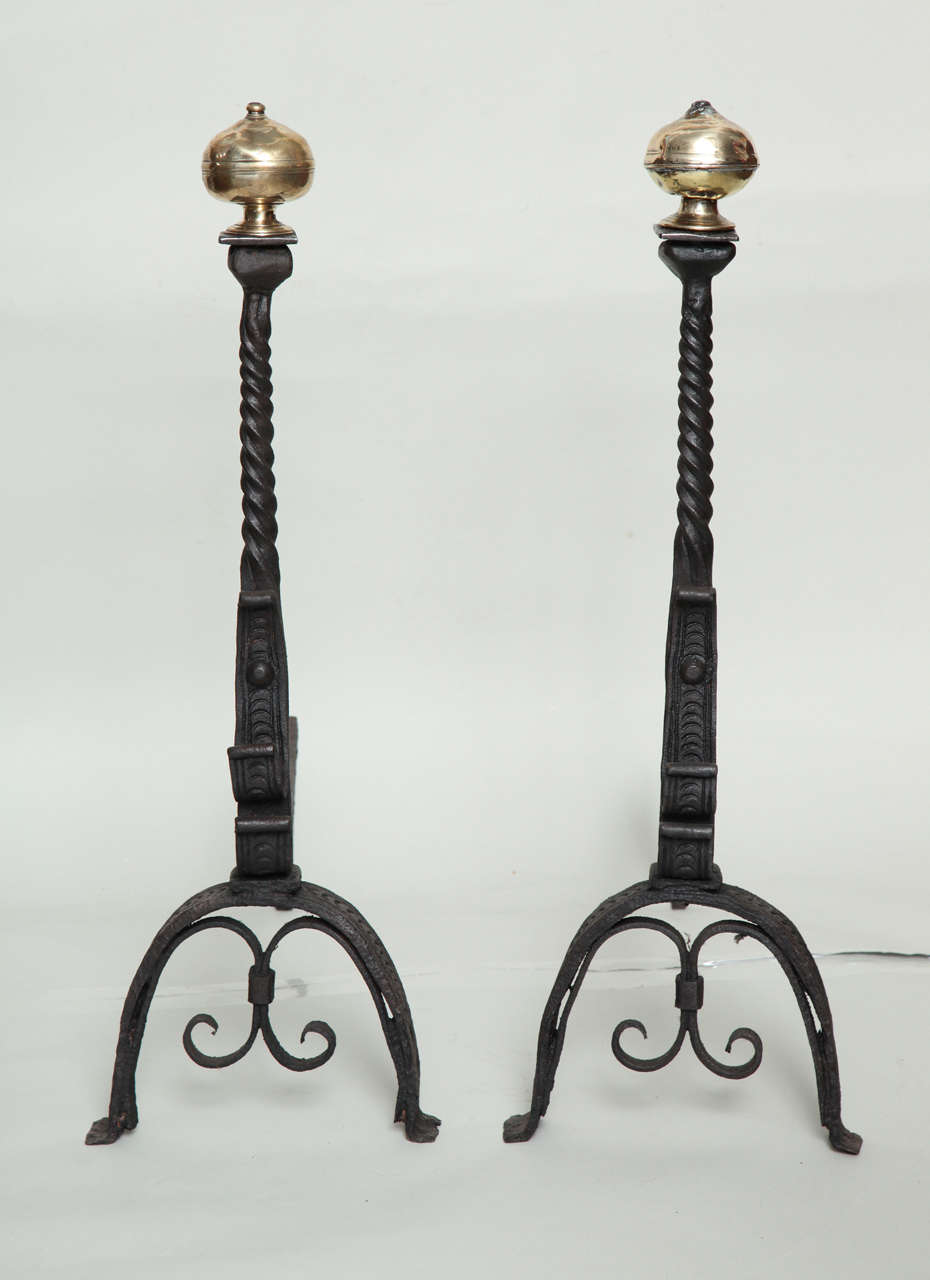 Good pair of 18th Century brass and wrought iron andirons, the suppressed ball finials over twisted shafts, the arched legs with scroll brackets.