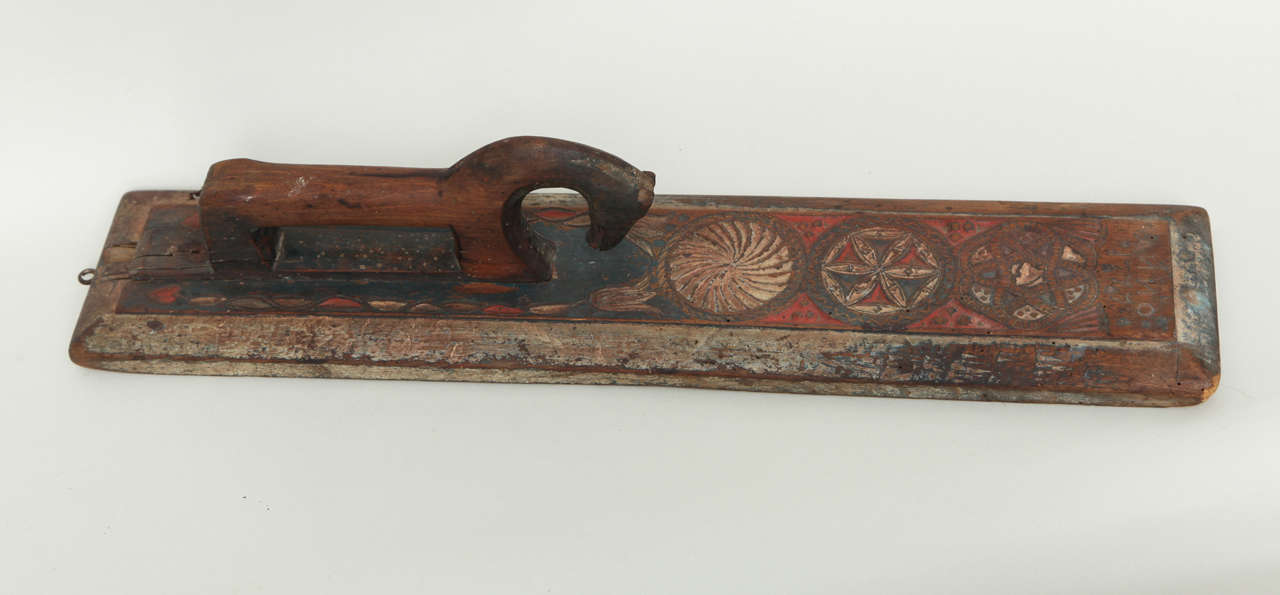 Charming early 19th Century Swedish folk art mangle board having a stylized horse handle, the body with geometric carving and traces of original polychrome paint.