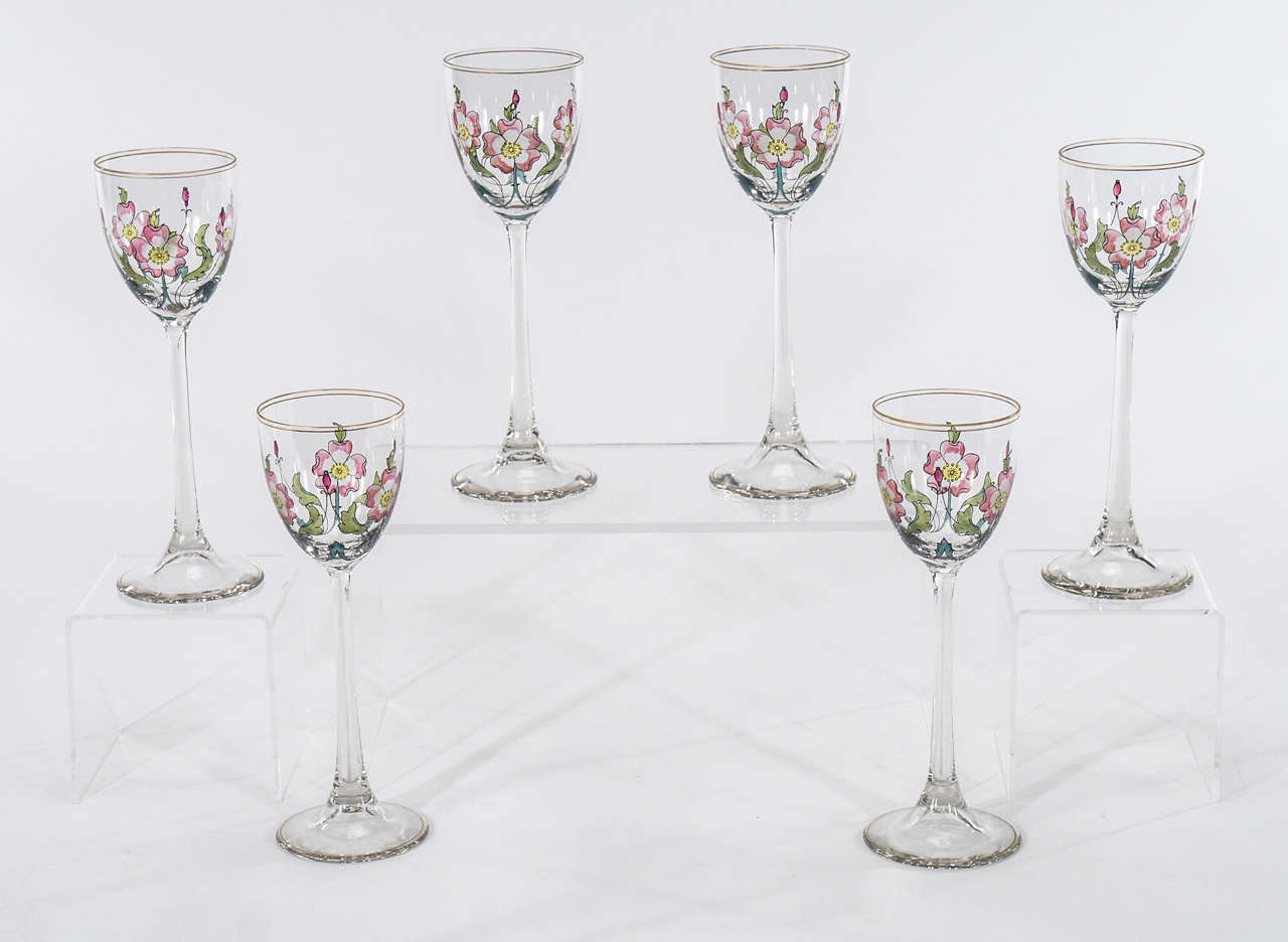 A perfect set of 6 tall hand blown crystal goblets with hand painted  transparent enamel floral decoration in the Art Nouveau style. Each is decorated with flowers and buds with beautifully detailed leaves and branches, trimmed in gold. Made by one