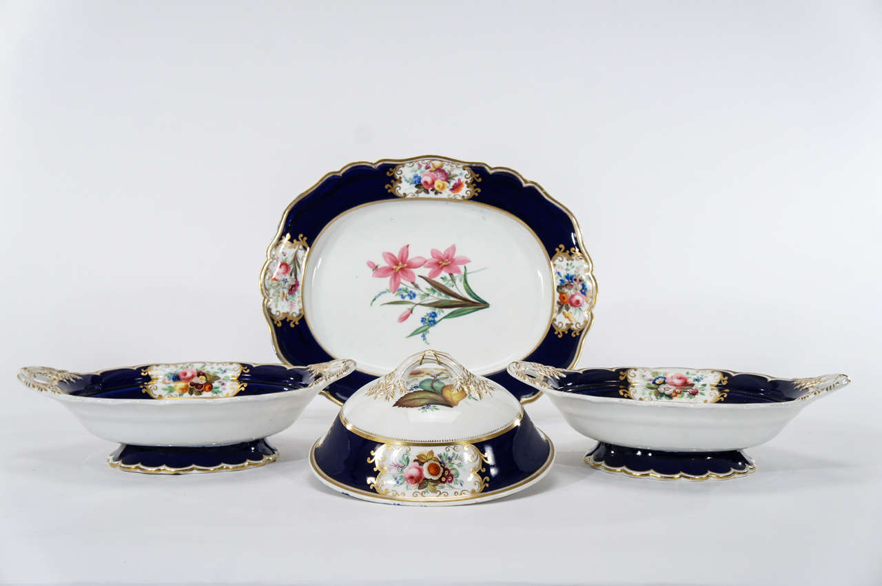 This is a lovely grouping of early 19th C. English hand painted botanical serving pieces.  Each piece is embellished with cobalt borders, shaped rims and gold trim and the vegetable tureens have the added decorative element of detailed wheat sheaves