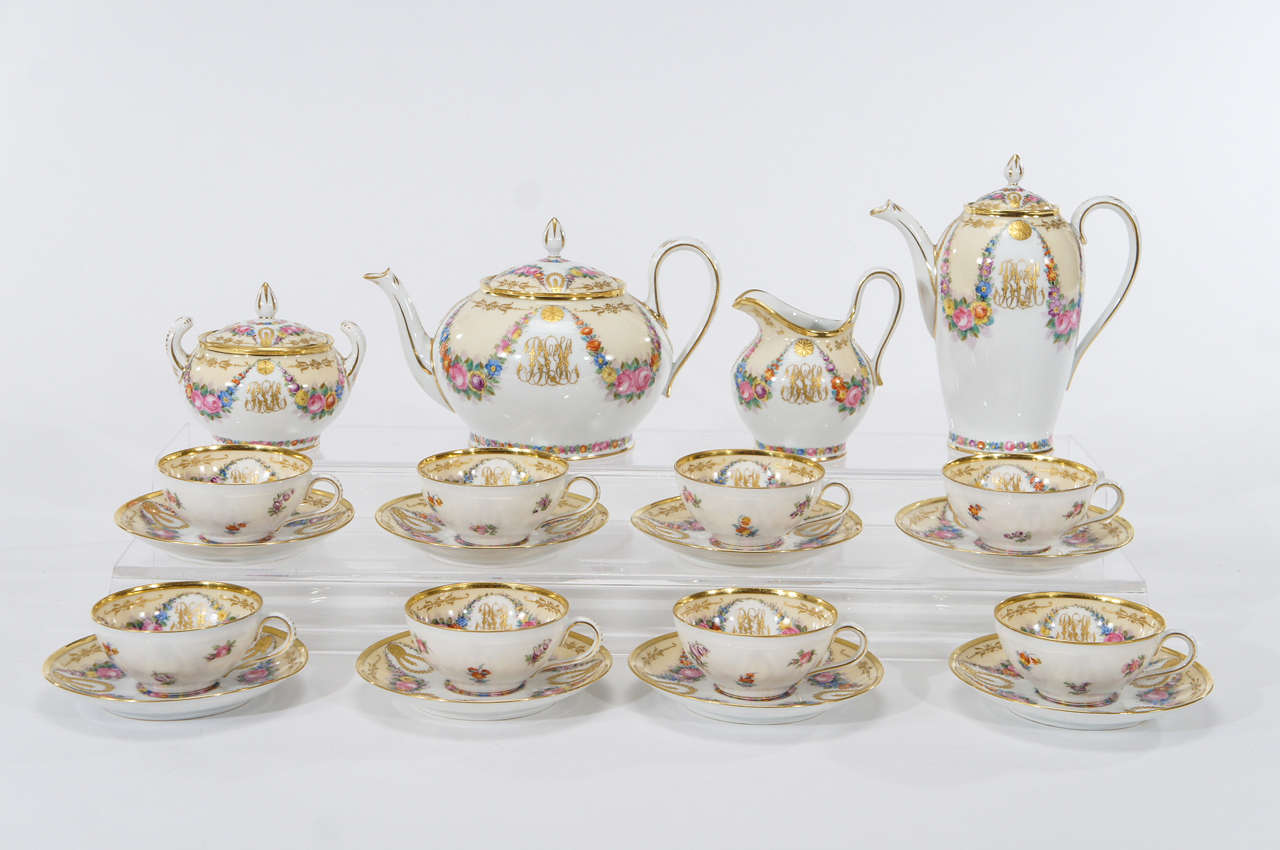 The finest workmanship is evident on this beautiful service consisting of a tall coffee pot, tea pot, creamer and sugar and eight matching cups and saucers. Each custom ordered piece is monogrammed in raised paste gold script and embellished with