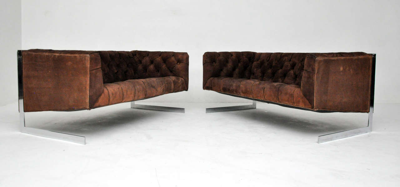Cantilever frame settees. Chrome frames suspend brown suede tufted seats.