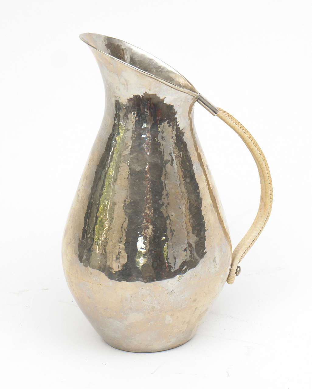 The form on this pitcher is absolutely lovely; it's curvy body and rope handle are undoubtedly influenced by Johan Rohde. We are unable to decipher the logo but can read LP. The number 2049 is clear and legible. A wonderful decorative accessory.