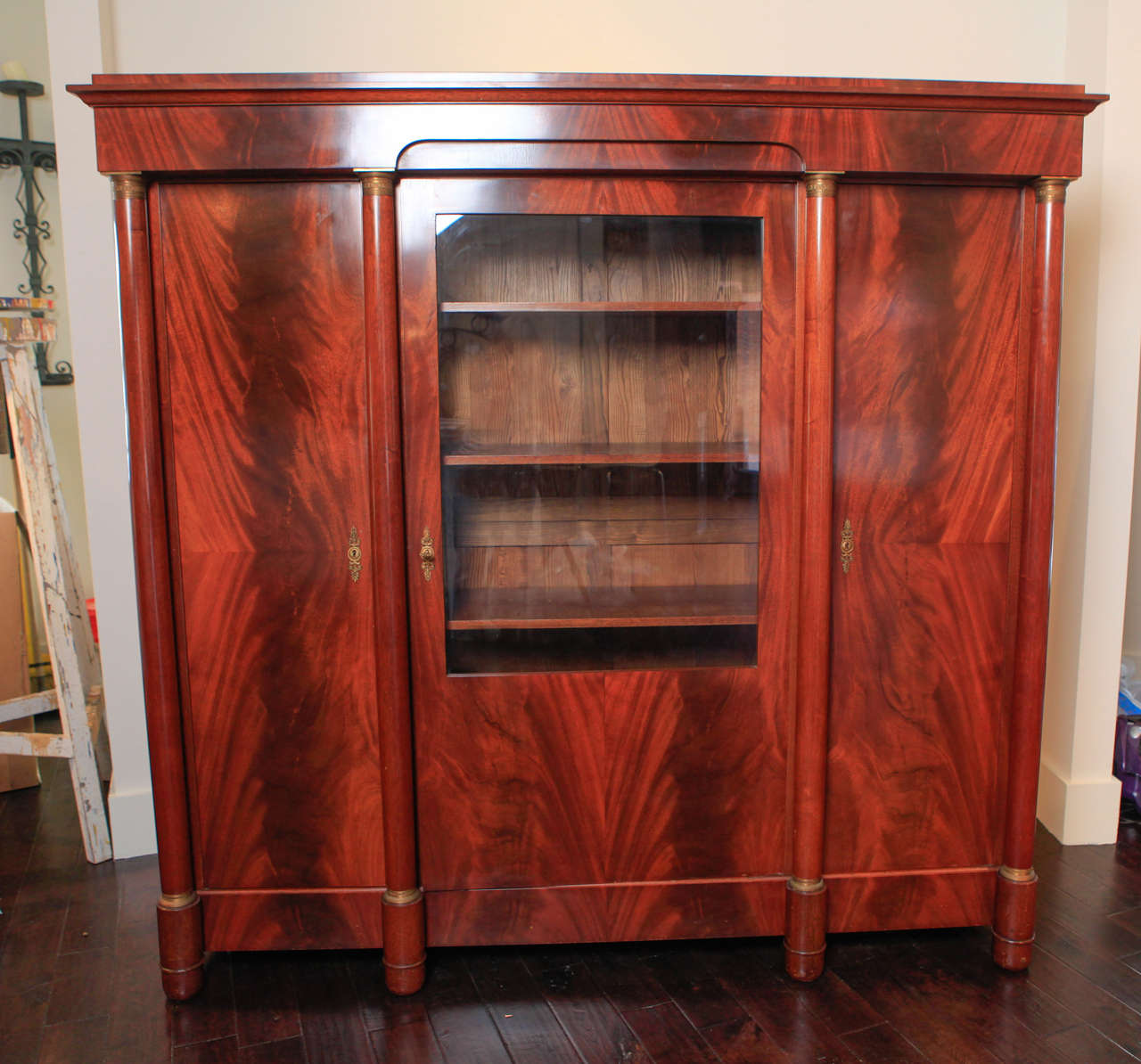 Armoire has bronze hardware. Locking doors; one door has glass. Four adjustable moveable shelves and one stationary shelf. Bookend matched mahogany veneer.