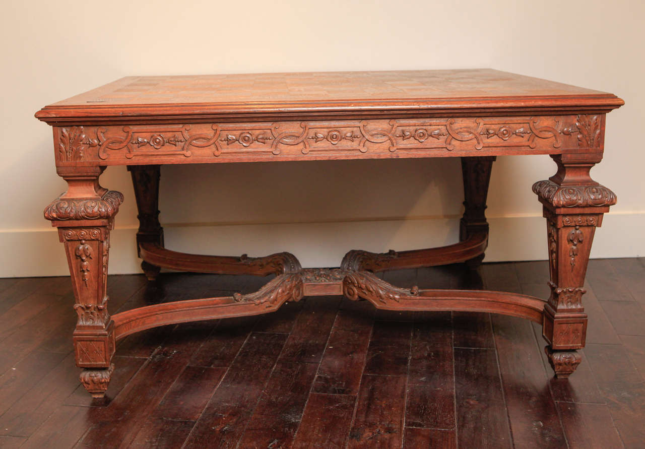 Oak table has carved legs, apron and stretcher. Parquet top. Could be used as a center table, dining table or desk.