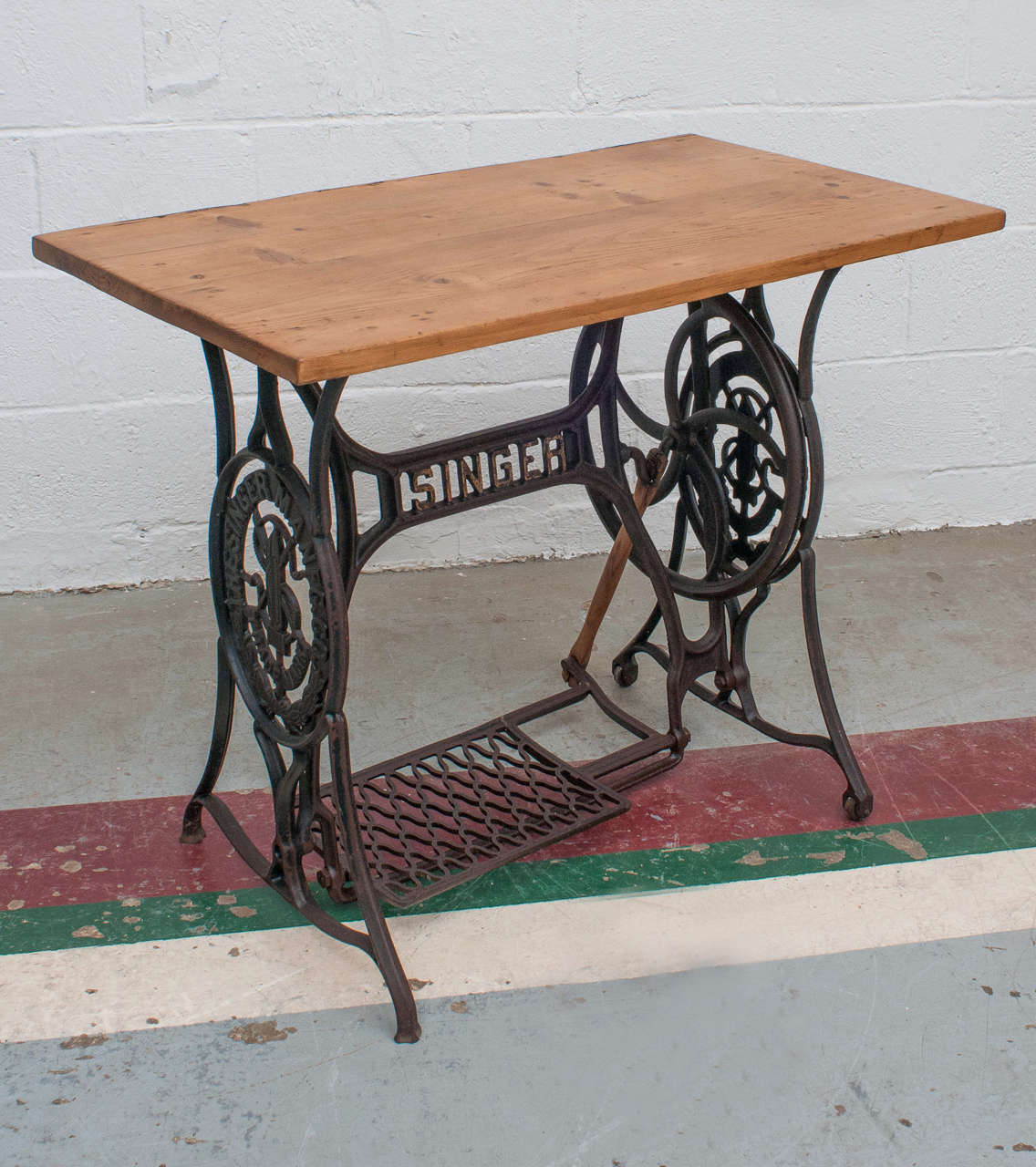 A lovely singer Art Nouveau cast iron sewing machine base featuring a fully working treadle with a reclaimed pine top.